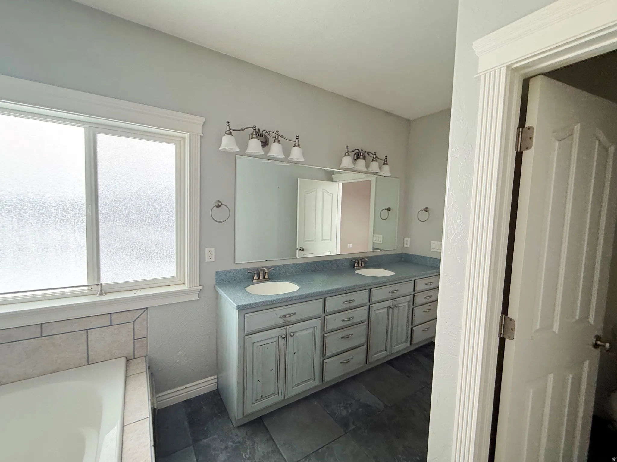 Full bathroom with double vanity and a garden tub