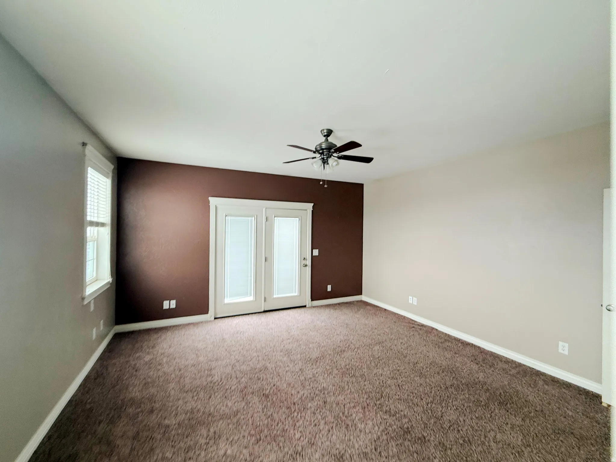 Unfurnished room featuring carpet and a ceiling fan