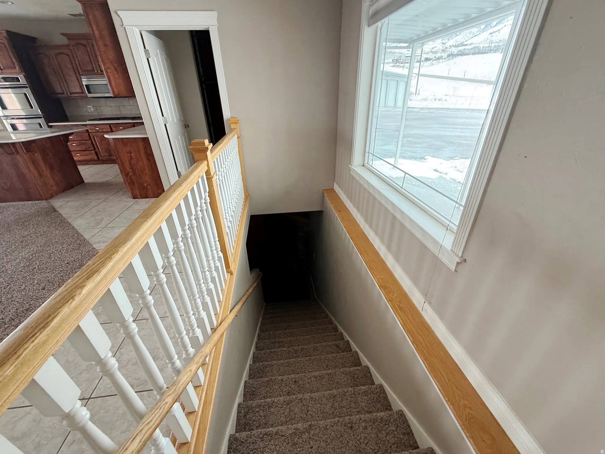 Stairway with carpet floors and tile patterned flooring