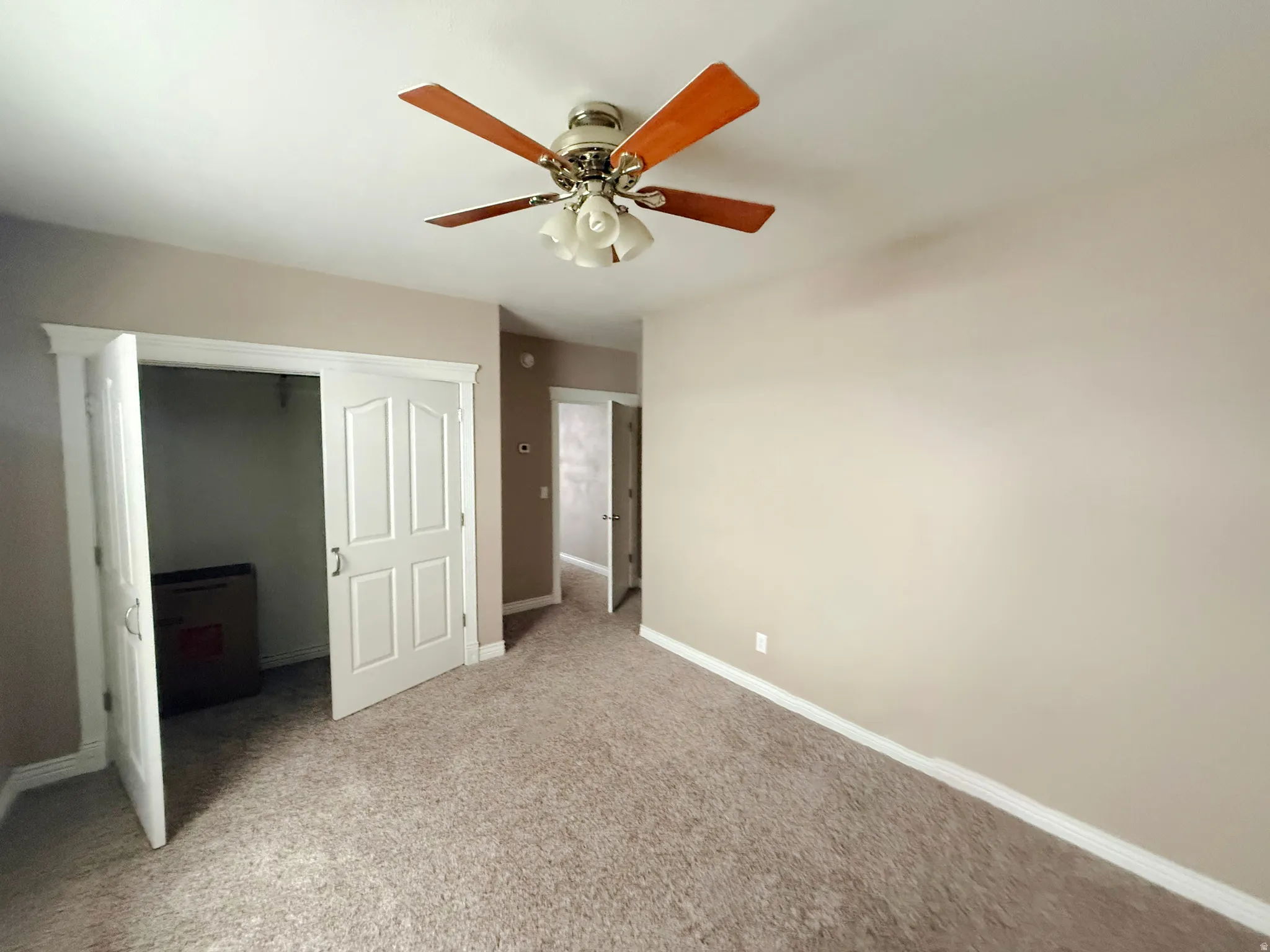 Unfurnished bedroom with carpet, ceiling fan, and a closet