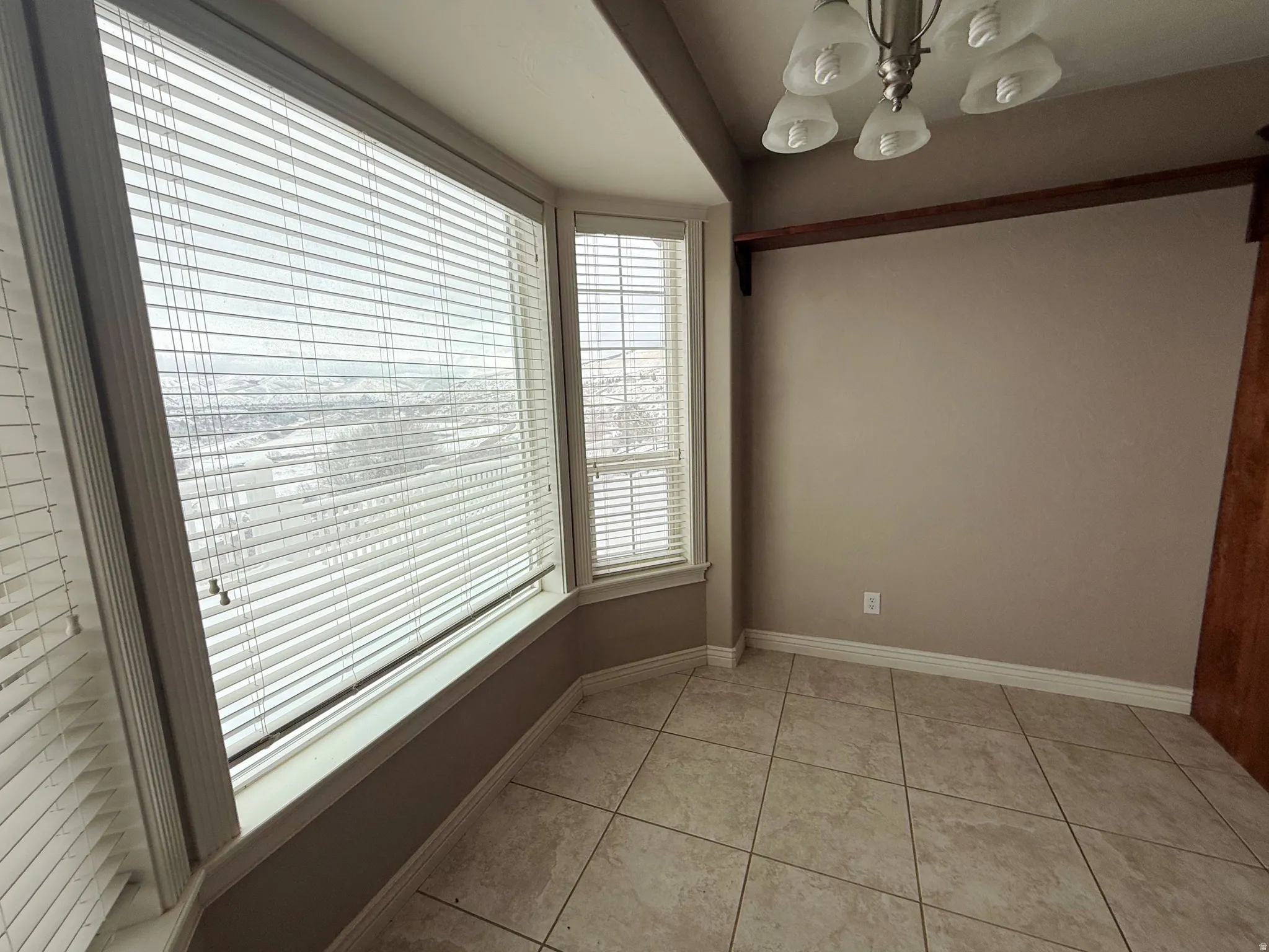 Unfurnished dining area with hanging lights and light tile patterned floors