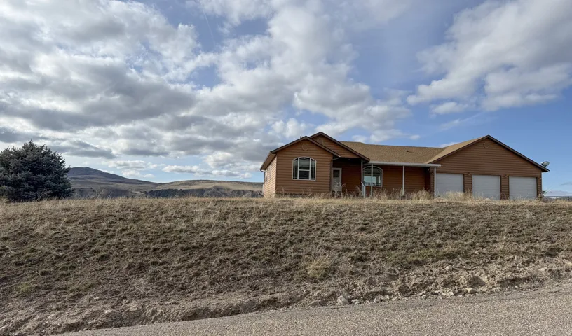 Single story home with log veneer siding, a mountain view, and a garage