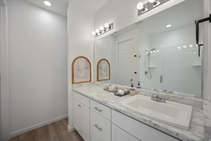 Primary bathroom. Large walk in shower, large vanity with sink, storage and private toilet room.