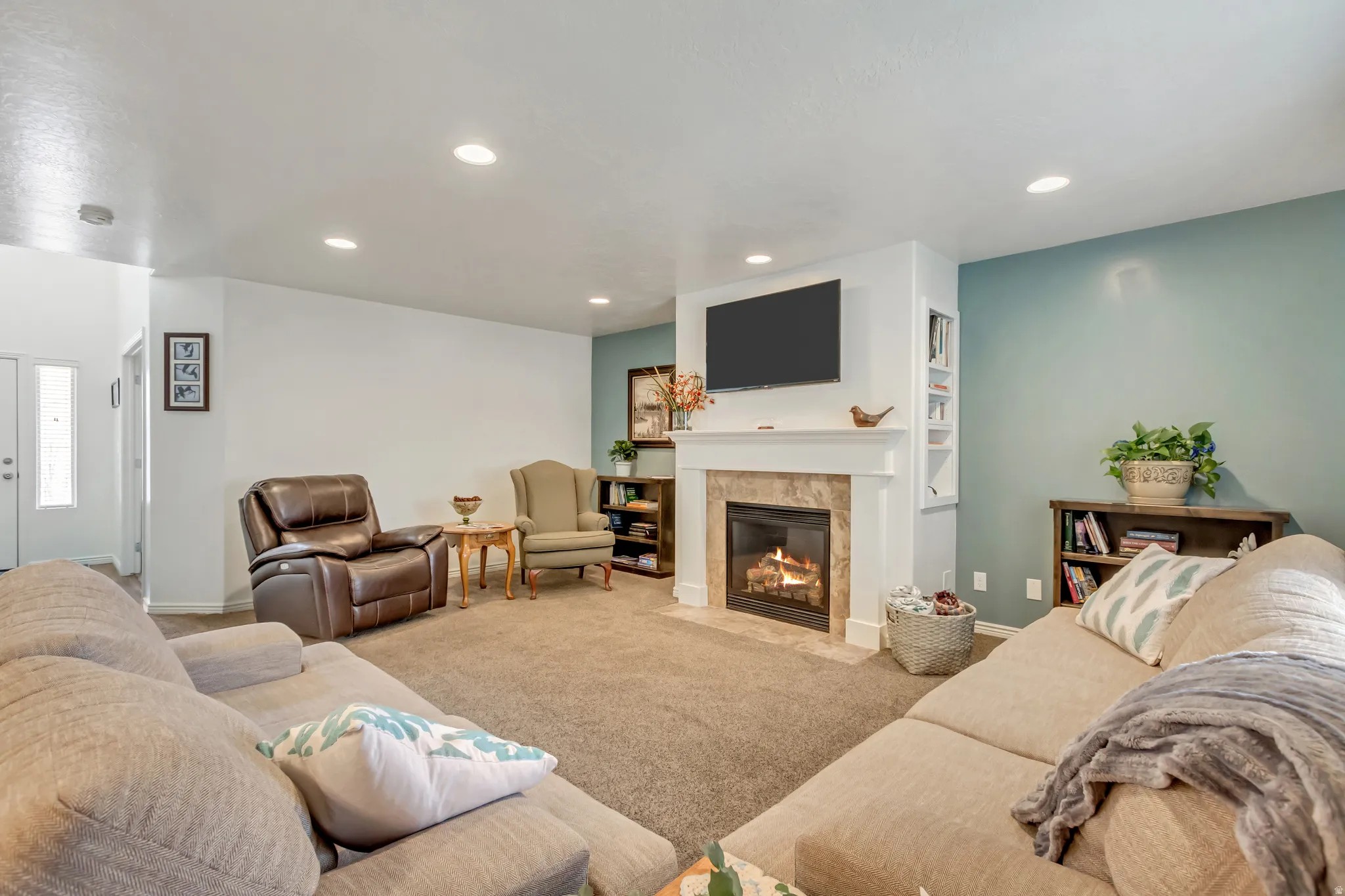 Carpeted living area with a tile fireplace and recessed lighting
