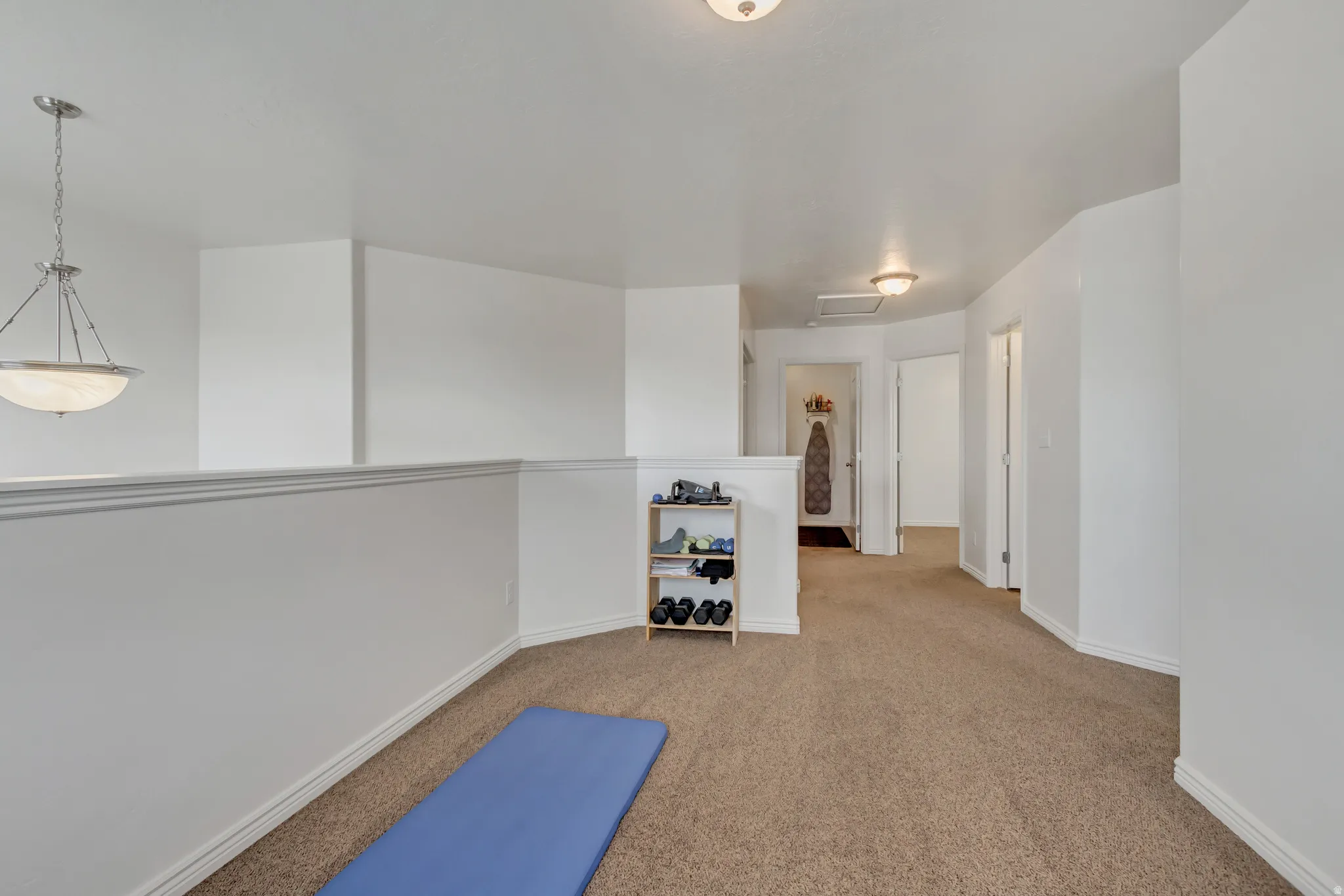 Exercise room with attic access and light colored carpet