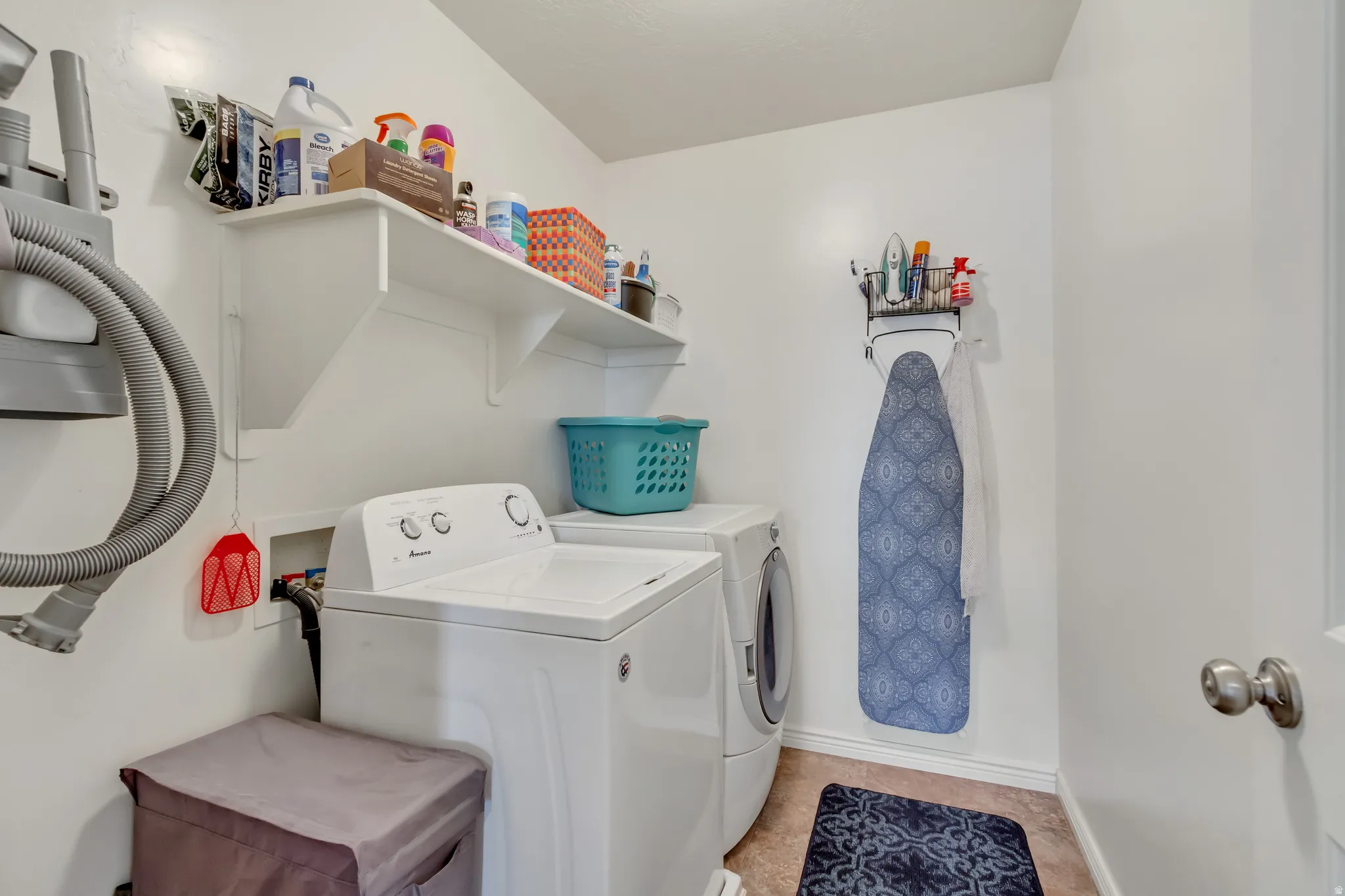 Laundry room with washer and clothes dryer and baseboards