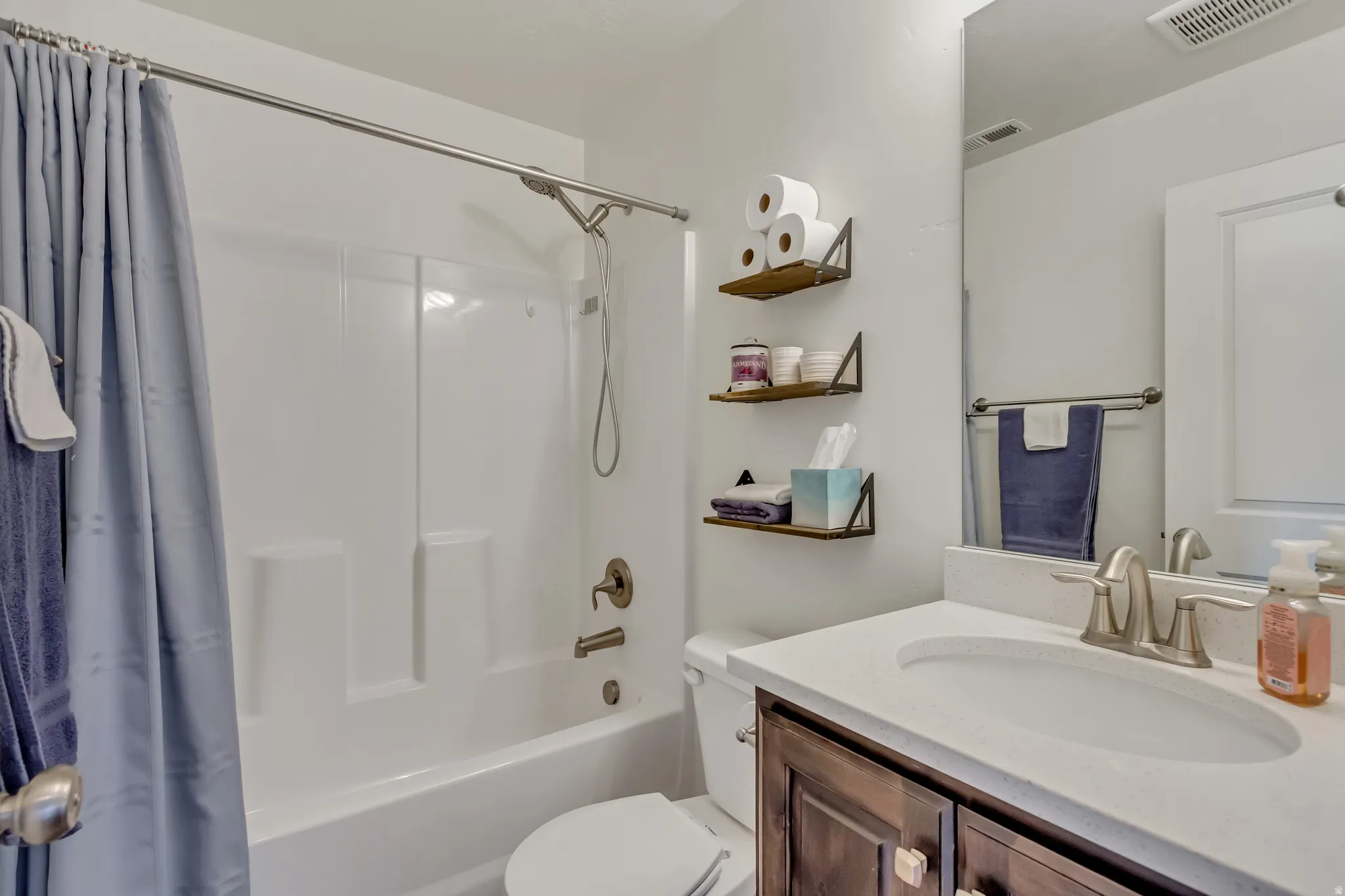 Bathroom featuring vanity and shower / tub combo with curtain