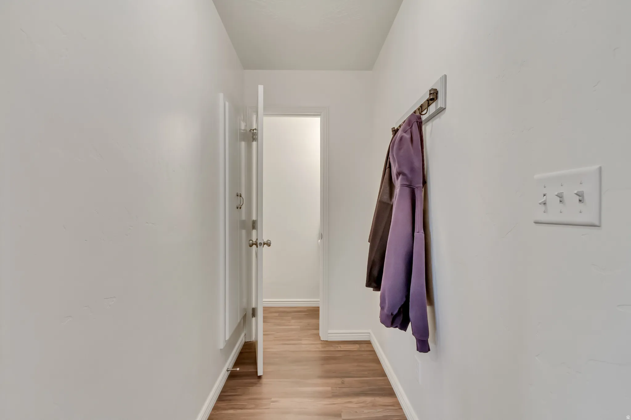 Hallway featuring baseboards and light wood-style flooring
