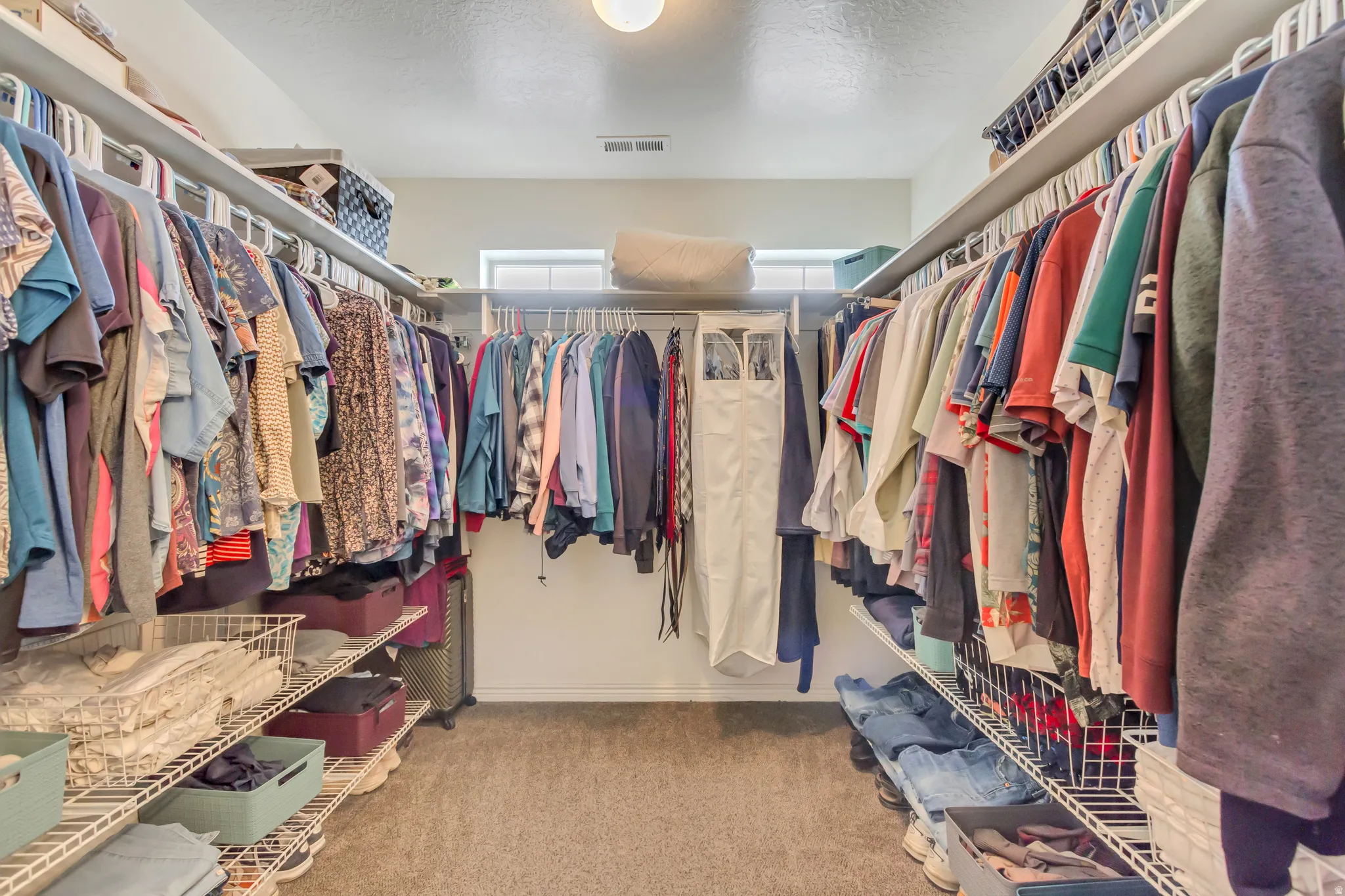 Walk in closet featuring light carpet