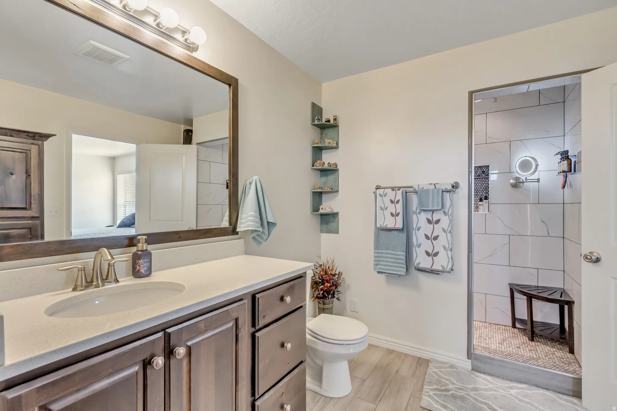 Bathroom featuring vanity, walk in shower, and wood tiled floors