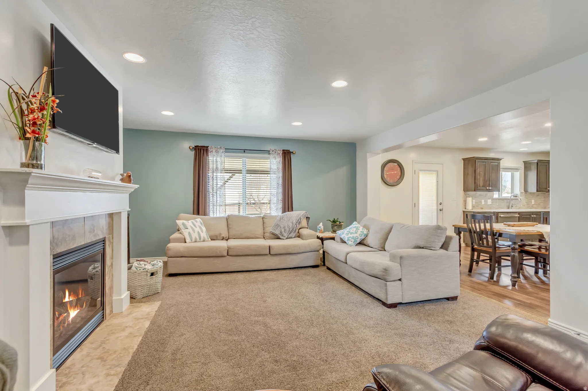 Living area with recessed lighting, plenty of natural light, and a tiled fireplace