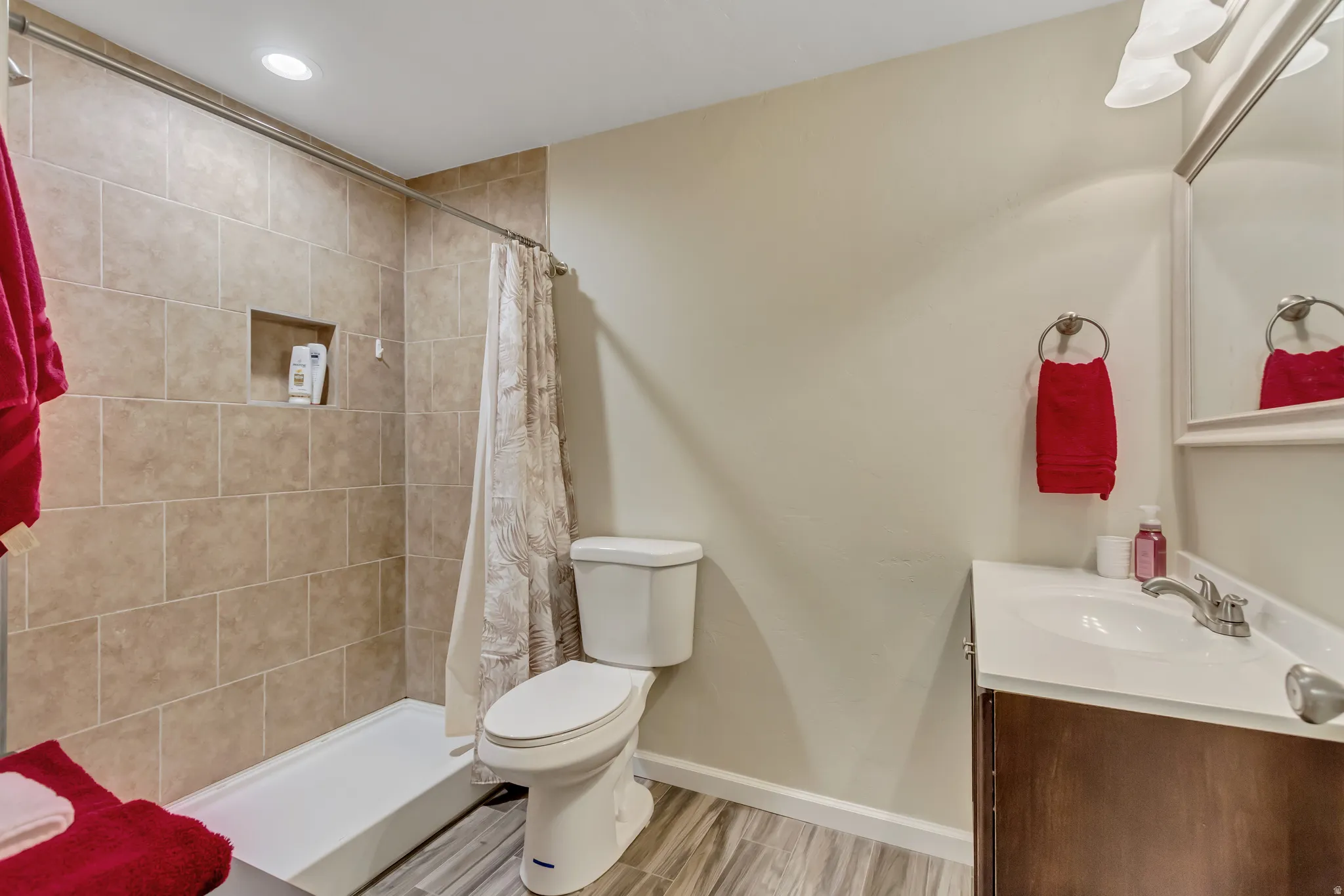 Bathroom with vanity, a shower stall, light wood-type flooring, and recessed lighting