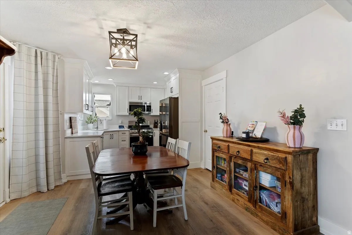 Dining space with light wood-style floors, recessed lighting, and a textured ceiling