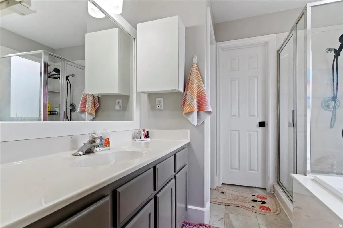 Full bathroom with vanity and a stall shower
