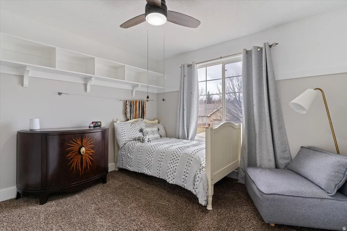 Bedroom featuring dark carpet and ceiling fan