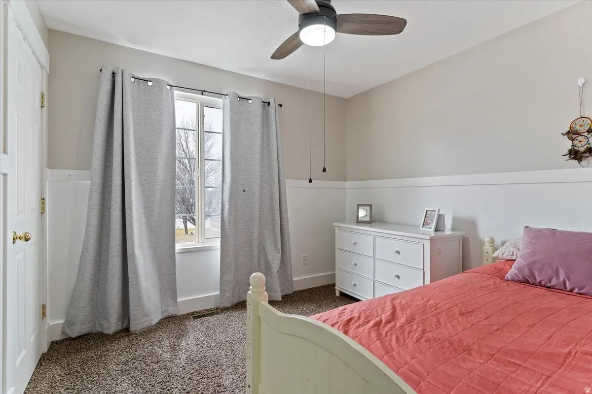 Bedroom featuring dark carpet and a ceiling fan