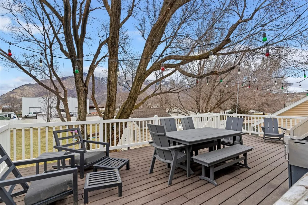 Wooden terrace featuring a mountain view and outdoor dining space