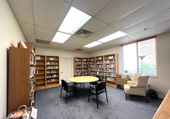 Library  area featuring wall of books and a paneled ceiling