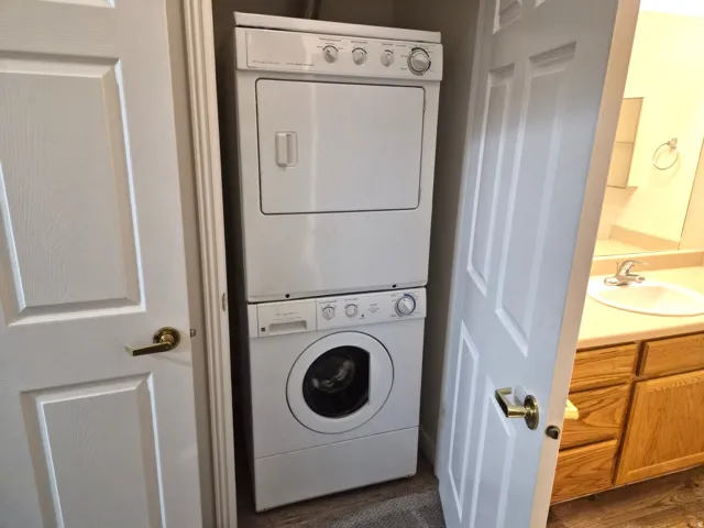 Laundry area with stacked washer and clothes dryer
