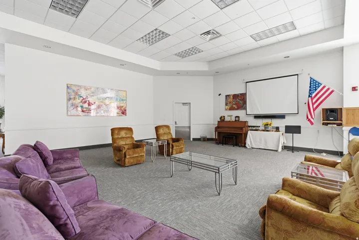 community Living room featuring chairs, couches and a movie screen