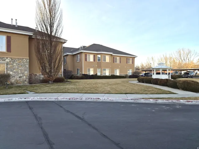 View of front of house featuring stone siding, stucco siding, a gazebo, and a front lawn