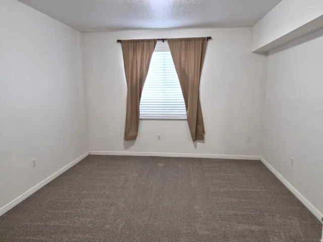 bedroom with dark colored carpet and a textured ceiling