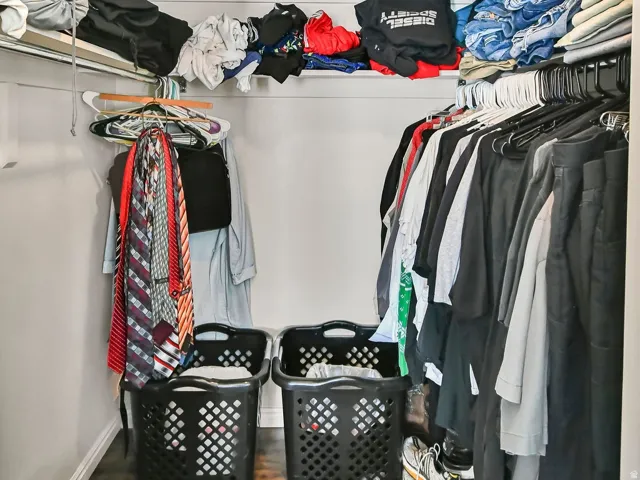 Walk in closet with dark wood-style floors