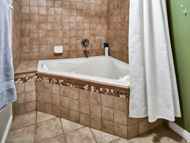 Bathroom featuring tiled shower / bath combo and a textured ceiling