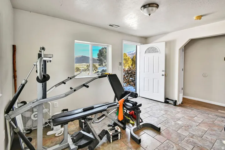 Exercise room featuring a textured ceiling, arched walkways, and a mountain view