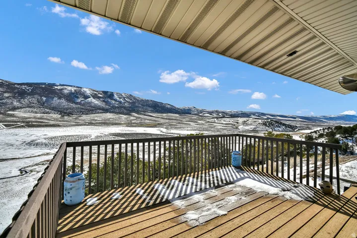 Snow covered deck with a mountain view