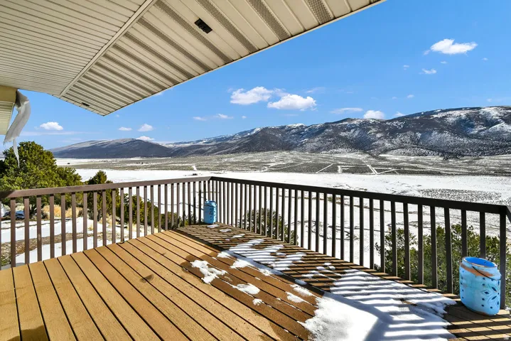Snow covered deck featuring a mountain view