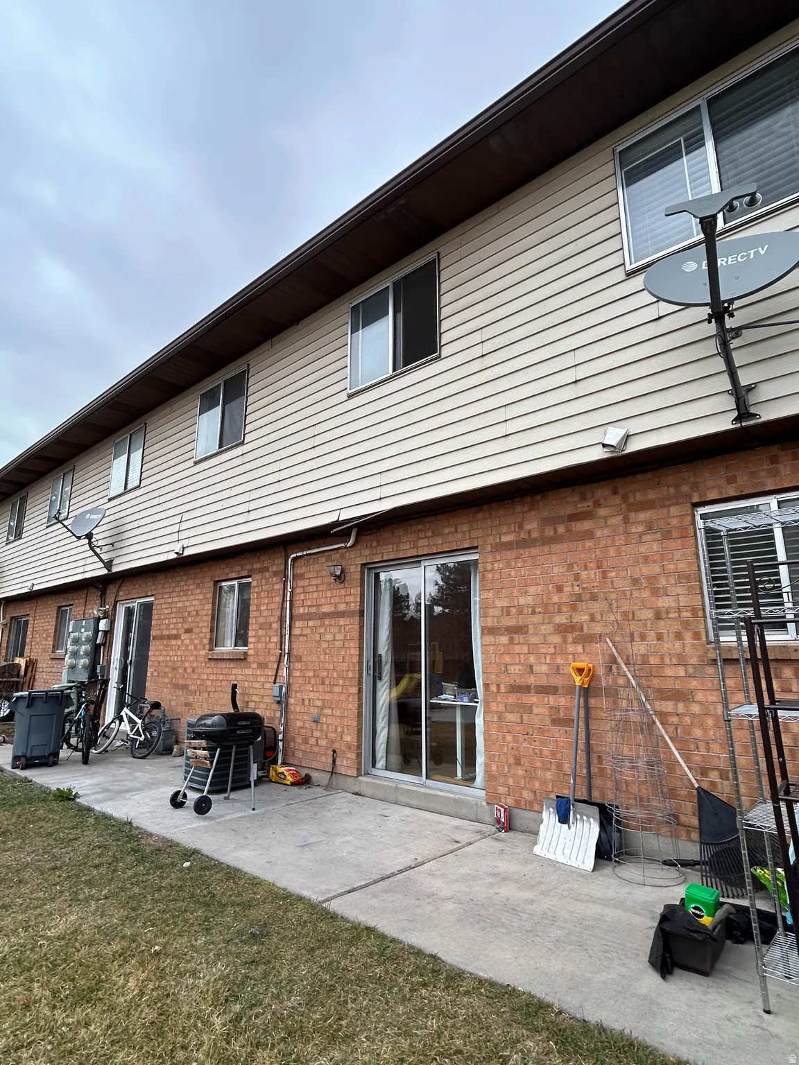 Back of house featuring a patio area, brick siding, and a yard