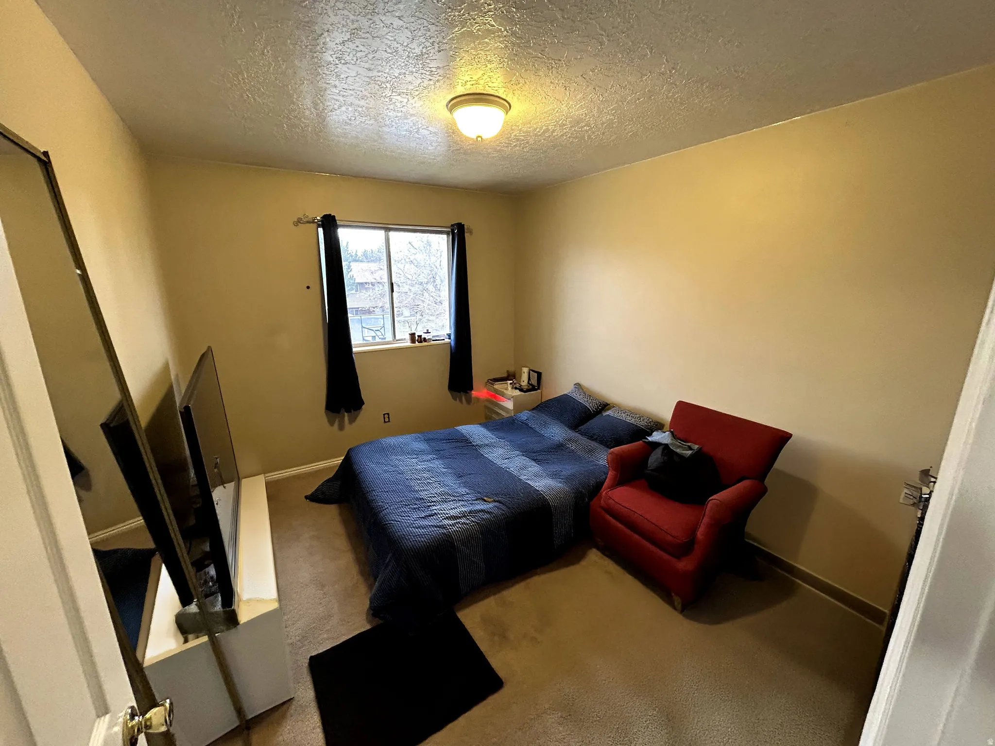 Bedroom featuring a textured ceiling and carpet