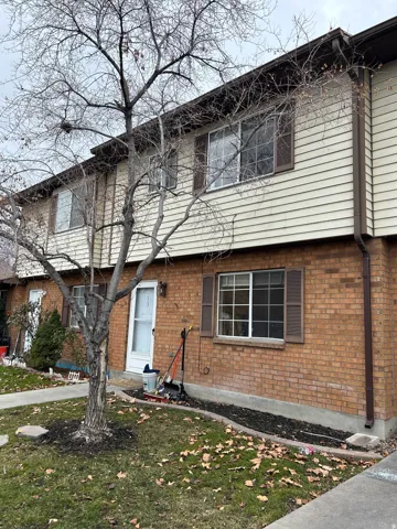 Colonial-style house with a front lawn and brick siding