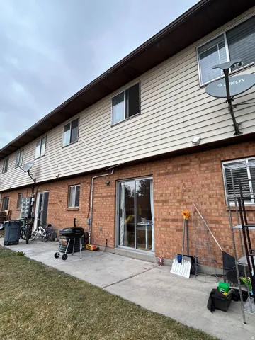 Back of house featuring a patio area, brick siding, and a yard