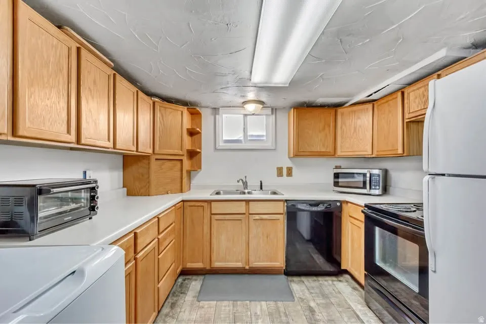 Kitchen with open shelves, black appliances, light countertops, and washer / dryer