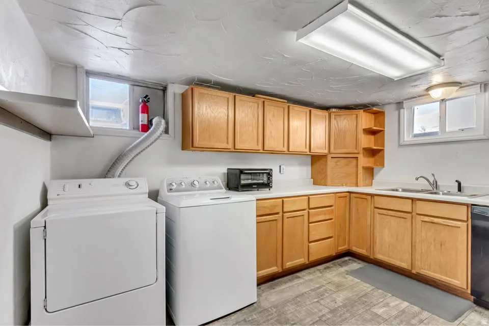 Laundry area featuring washing machine and clothes dryer and light wood-type flooring
