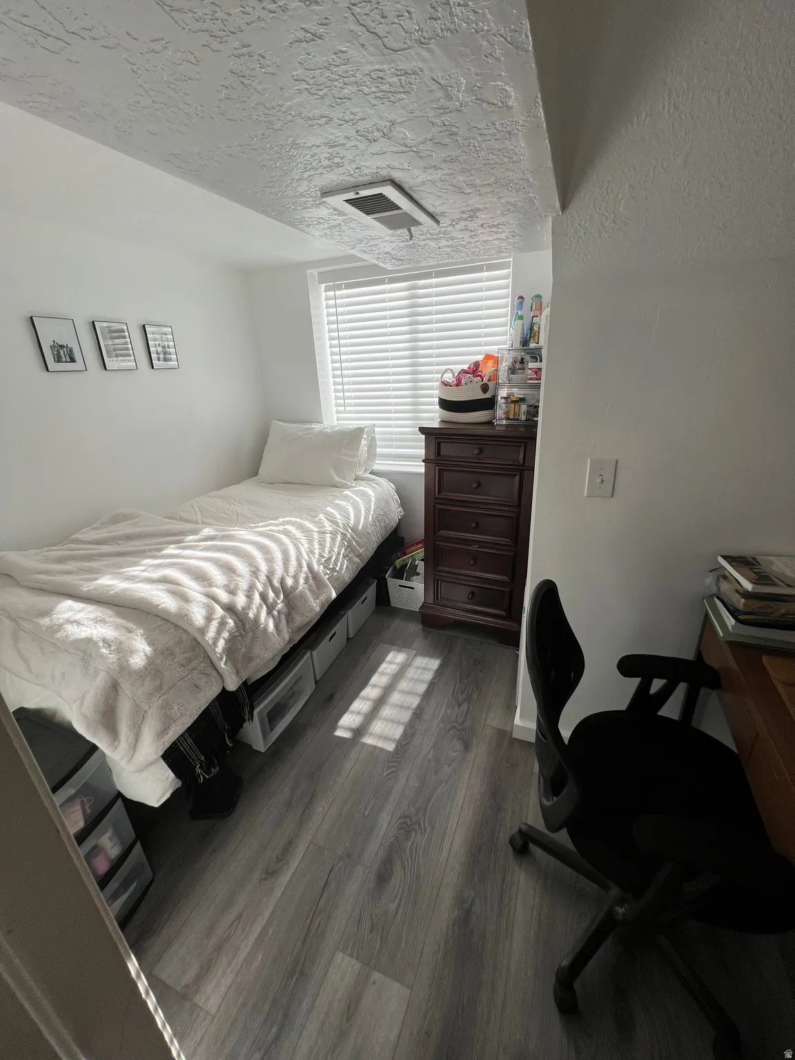Bedroom featuring a textured ceiling and dark wood-style flooring