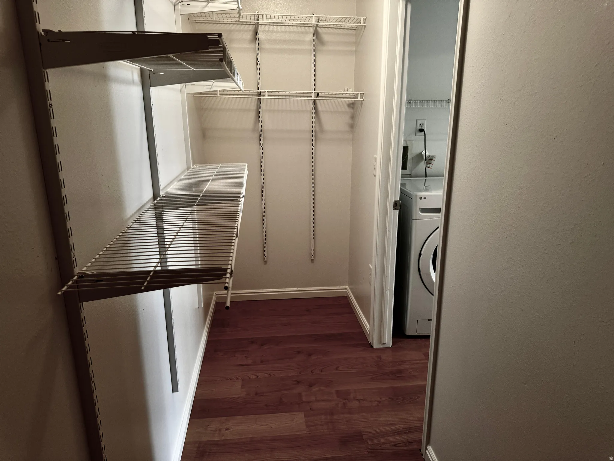 Walk in closet featuring washer / dryer and dark wood-style floors