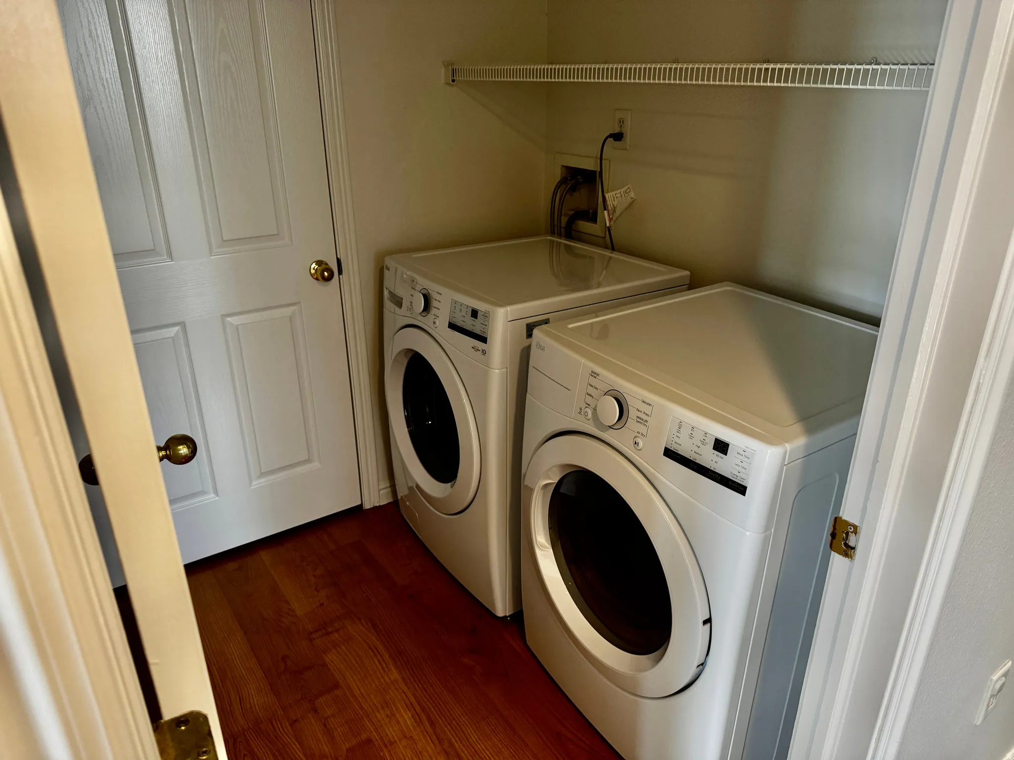 Laundry room featuring dark wood-style flooring and washing machine and dryer