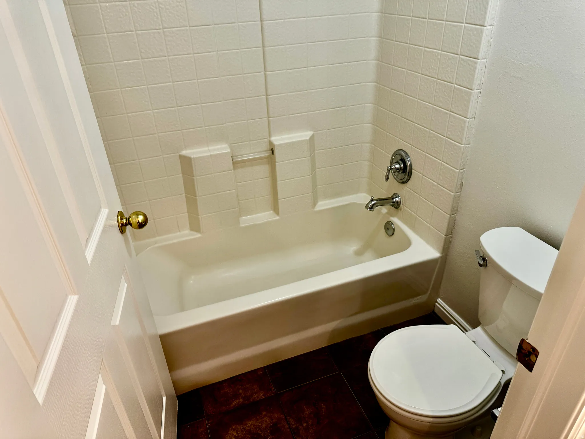 Full bath with shower / tub combination and dark tile patterned flooring