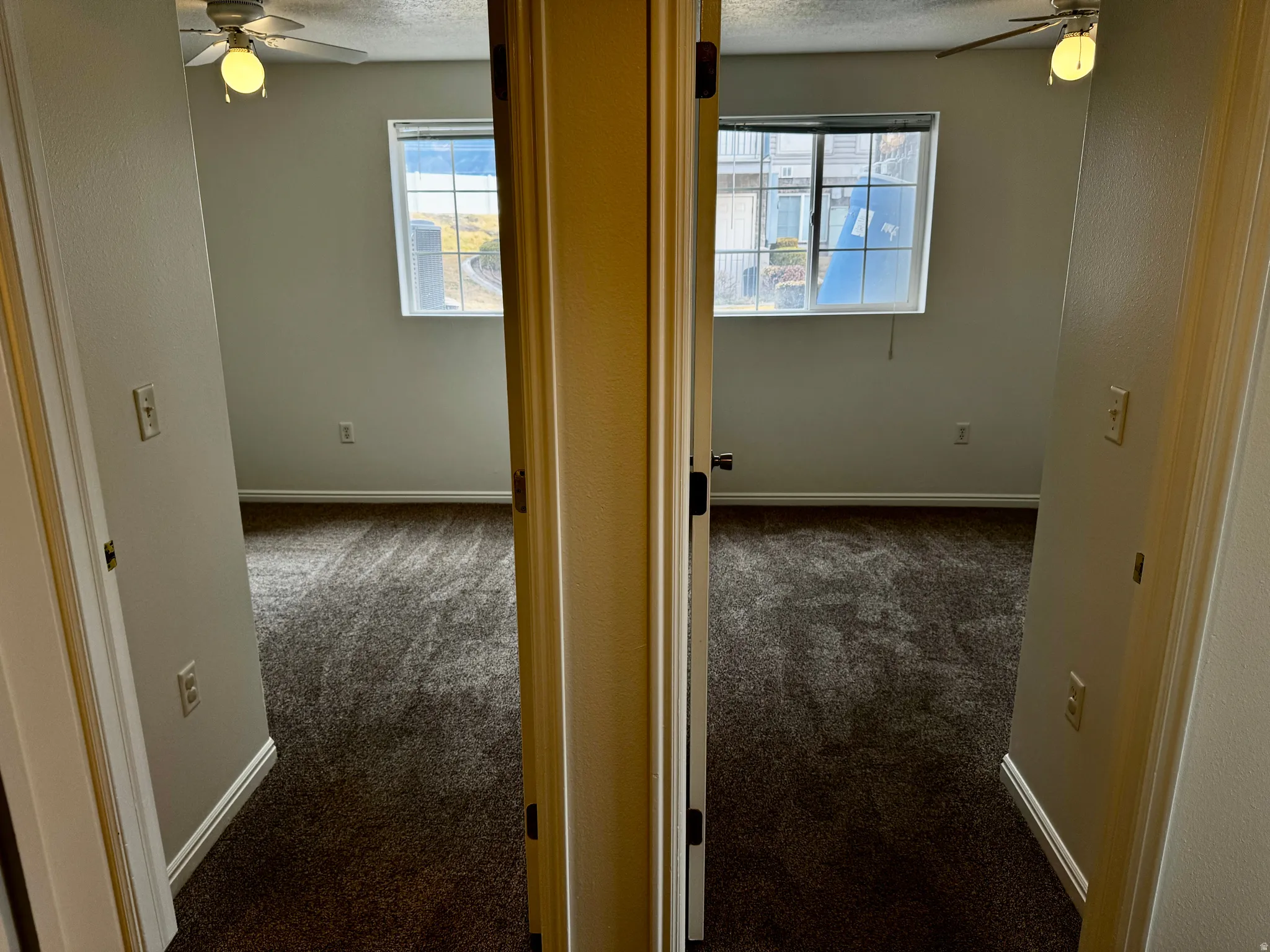 Hall featuring dark carpet and plenty of natural light