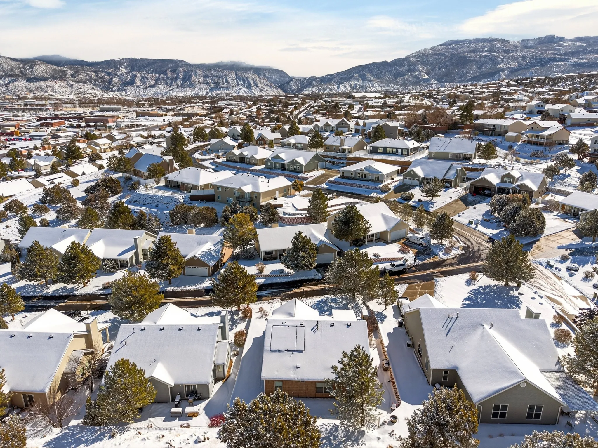 Snowy aerial view with a mountain view and a residential view