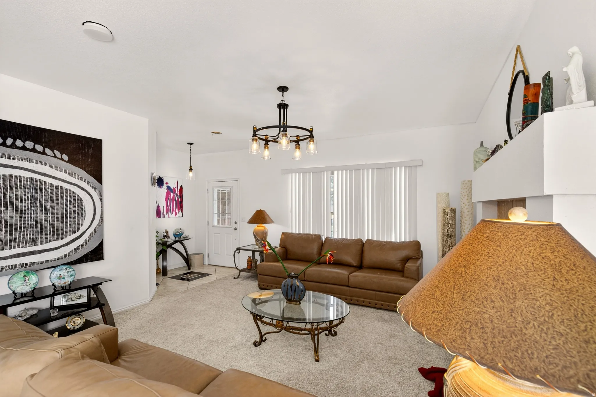 Carpeted living room featuring a chandelier and baseboards