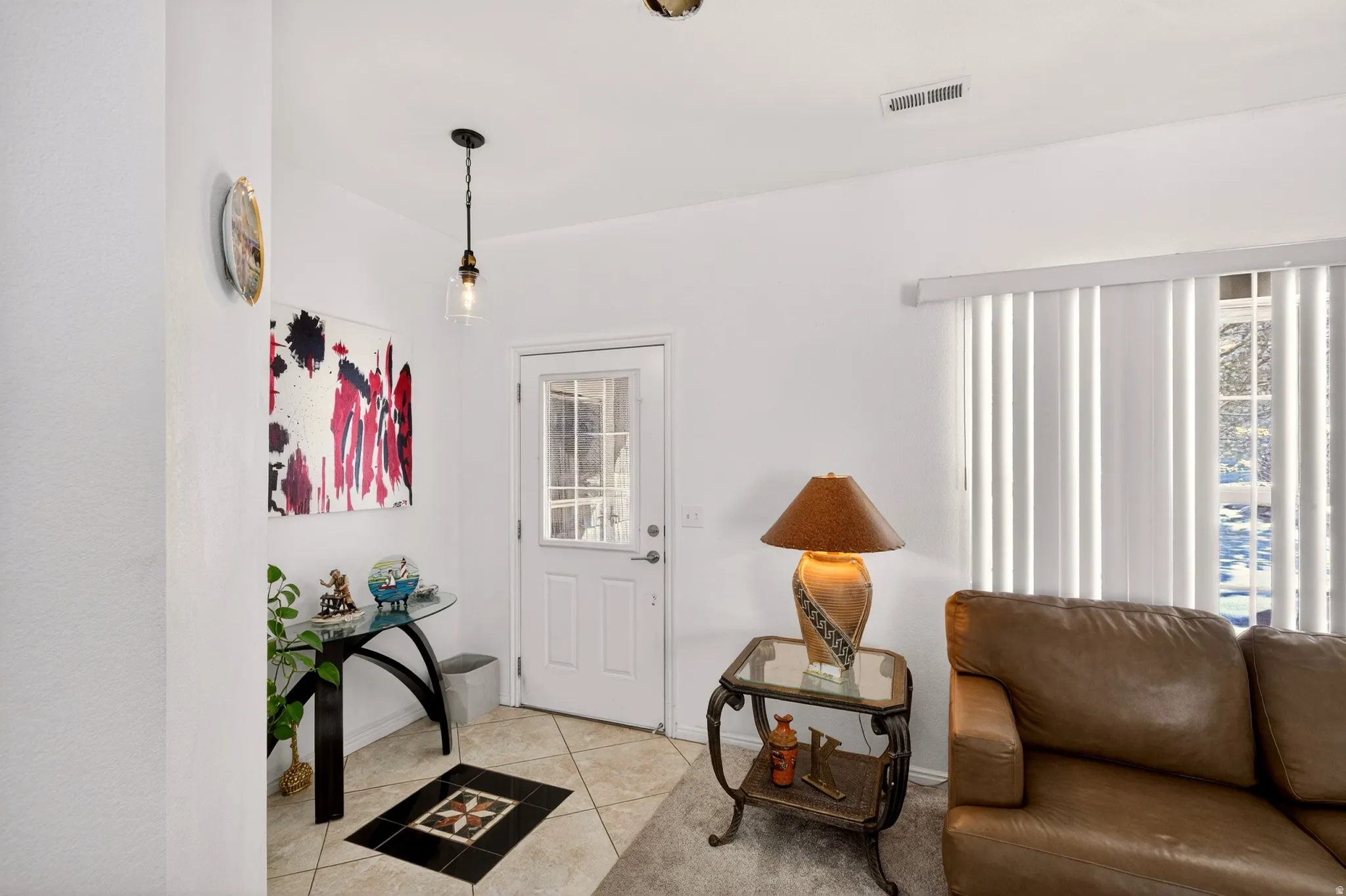 Foyer entrance featuring light tile patterned flooring and healthy amount of natural light