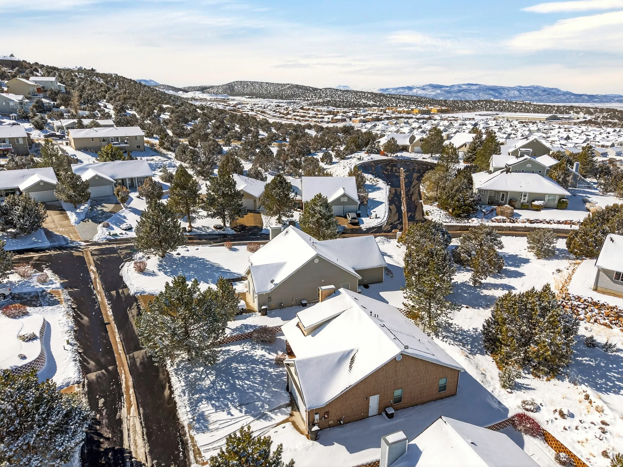 Snowy aerial view featuring a residential view and a mountain view
