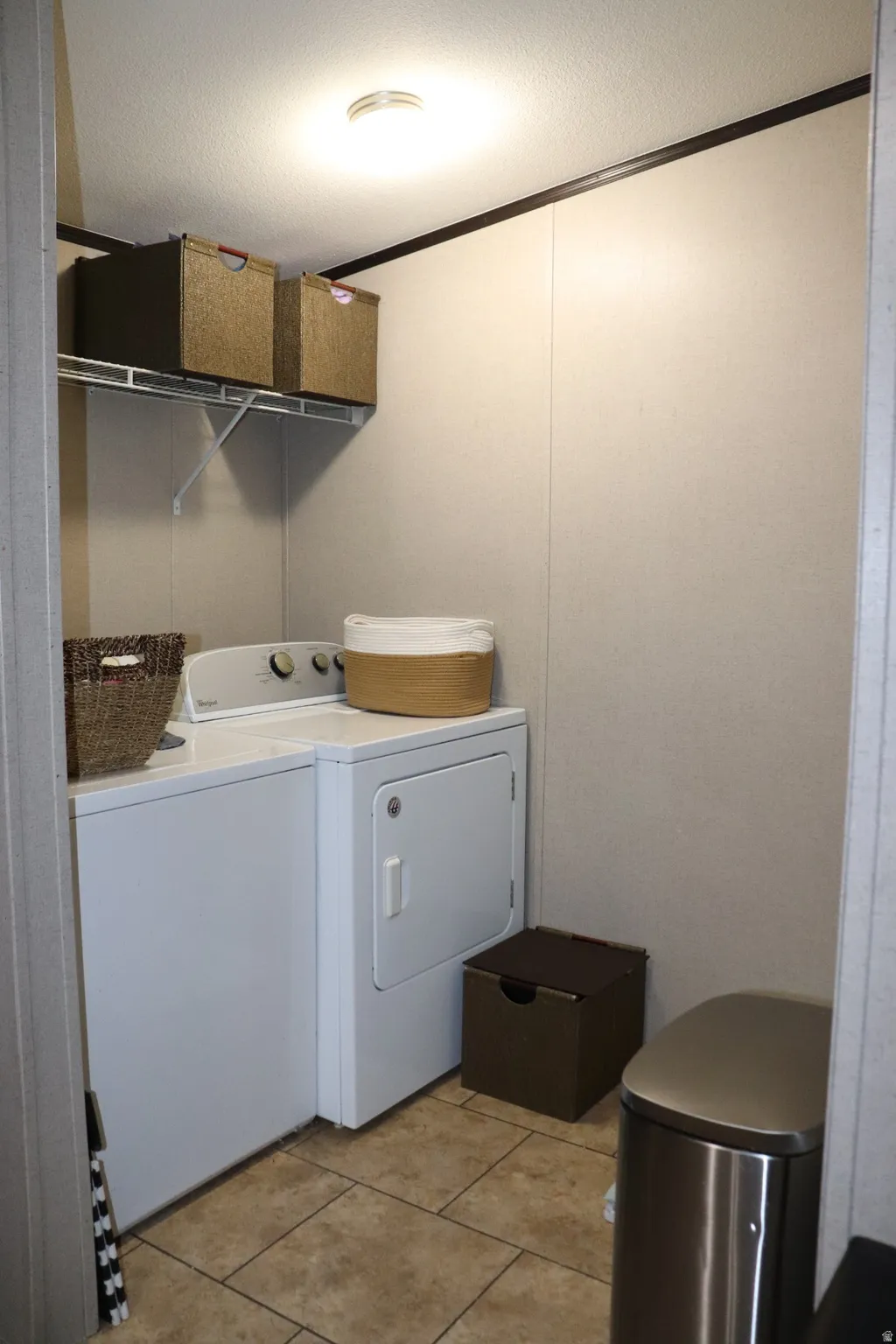 Laundry room featuring crown molding, a textured ceiling, and separate washer and dryer