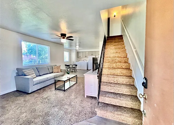 Living room featuring a textured ceiling, ceiling fan, and independent washer and dryer