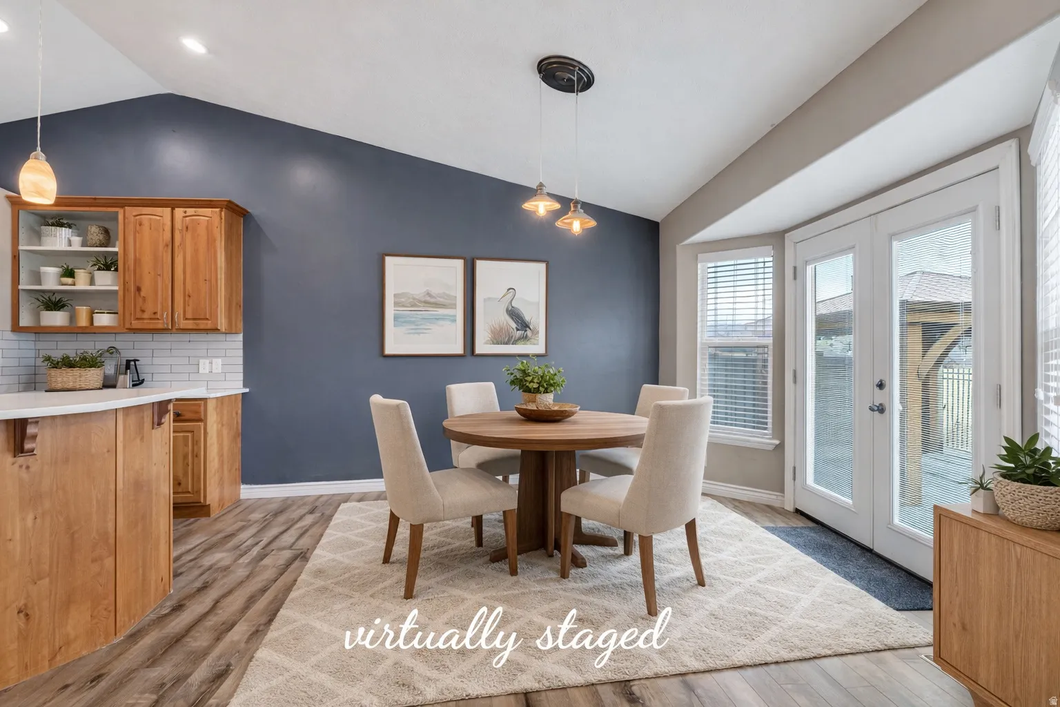 Dining area with vaulted ceiling, french doors, and light wood finished floors