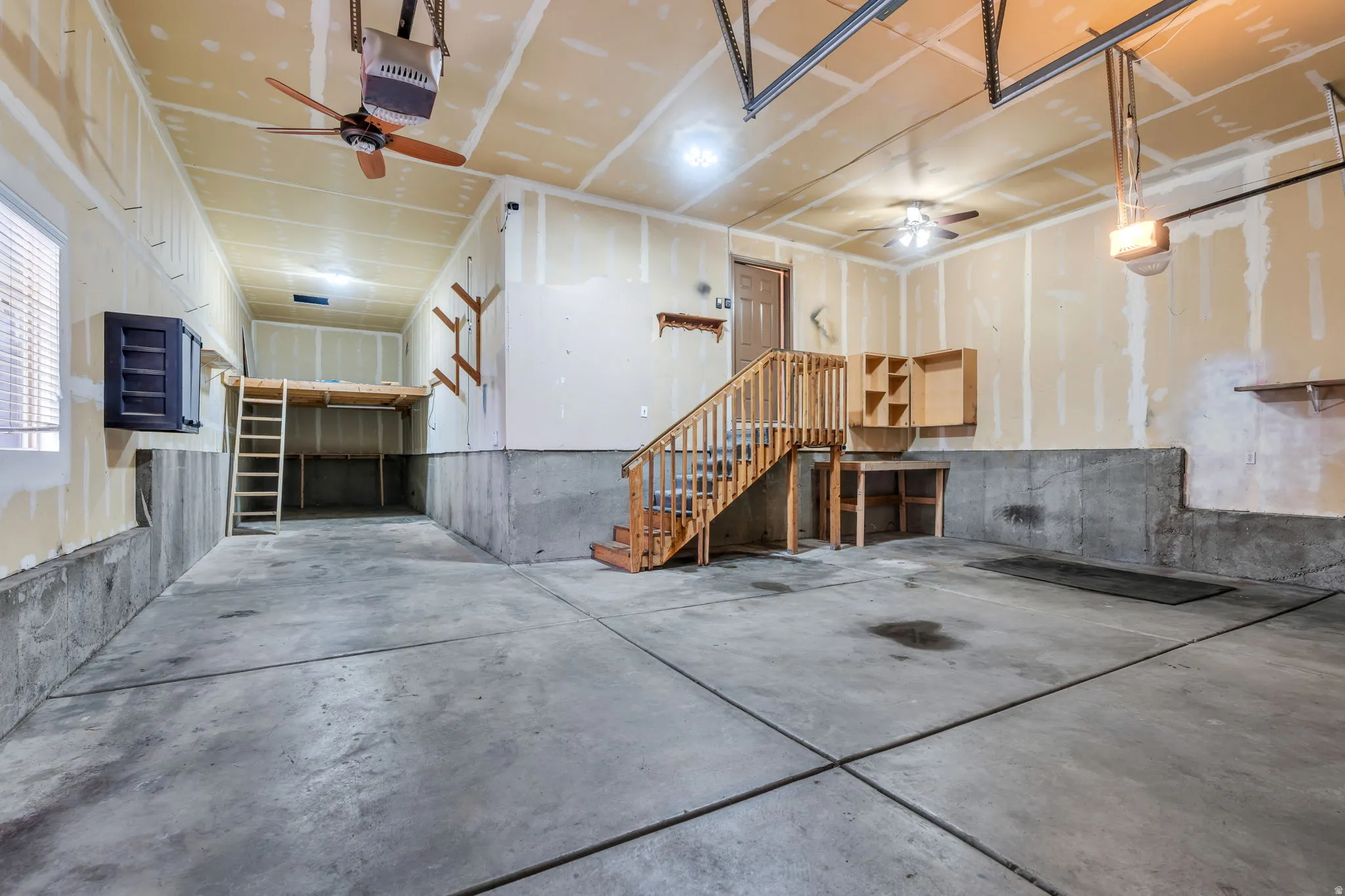 Garage featuring ceiling fan and a garage door opener